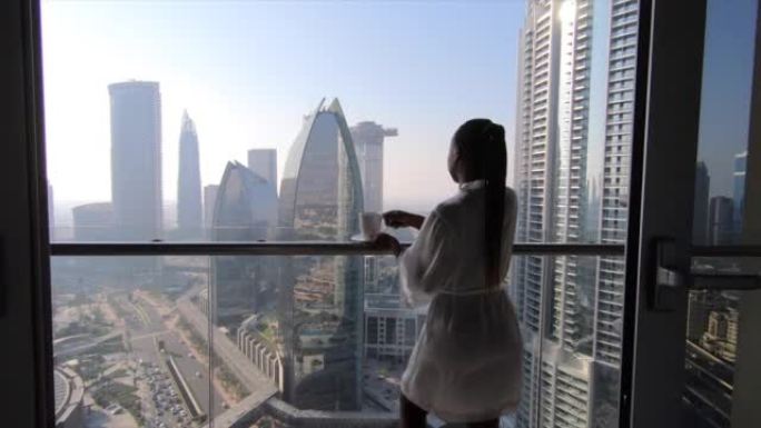 年轻的非洲妇女站在阳台上，俯瞰着未来的城市天际线