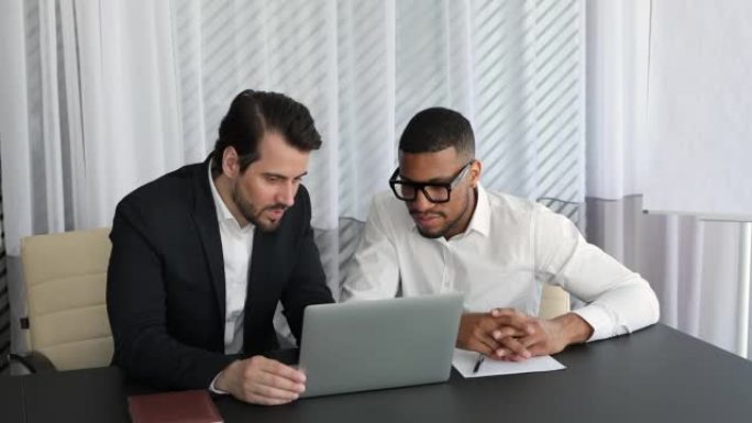 经验丰富的男性导师帮助黑人员工实习计算机工作