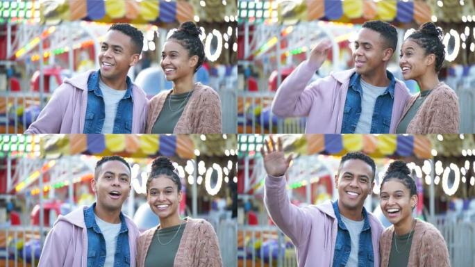 年轻的黑人夫妇在游乐园里微笑着挥手