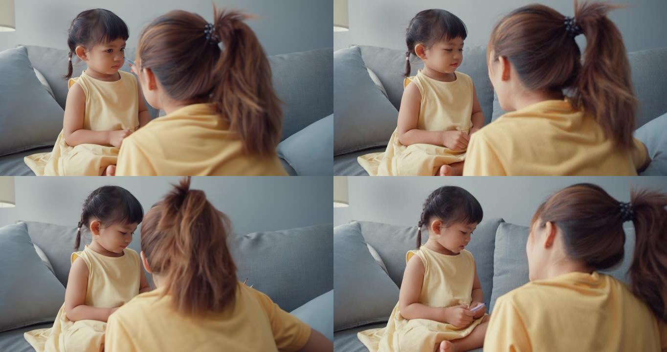 快乐快乐的亚洲家庭妈妈教女孩绘画使用相册和彩色铅笔在家里客厅的沙发上放松。