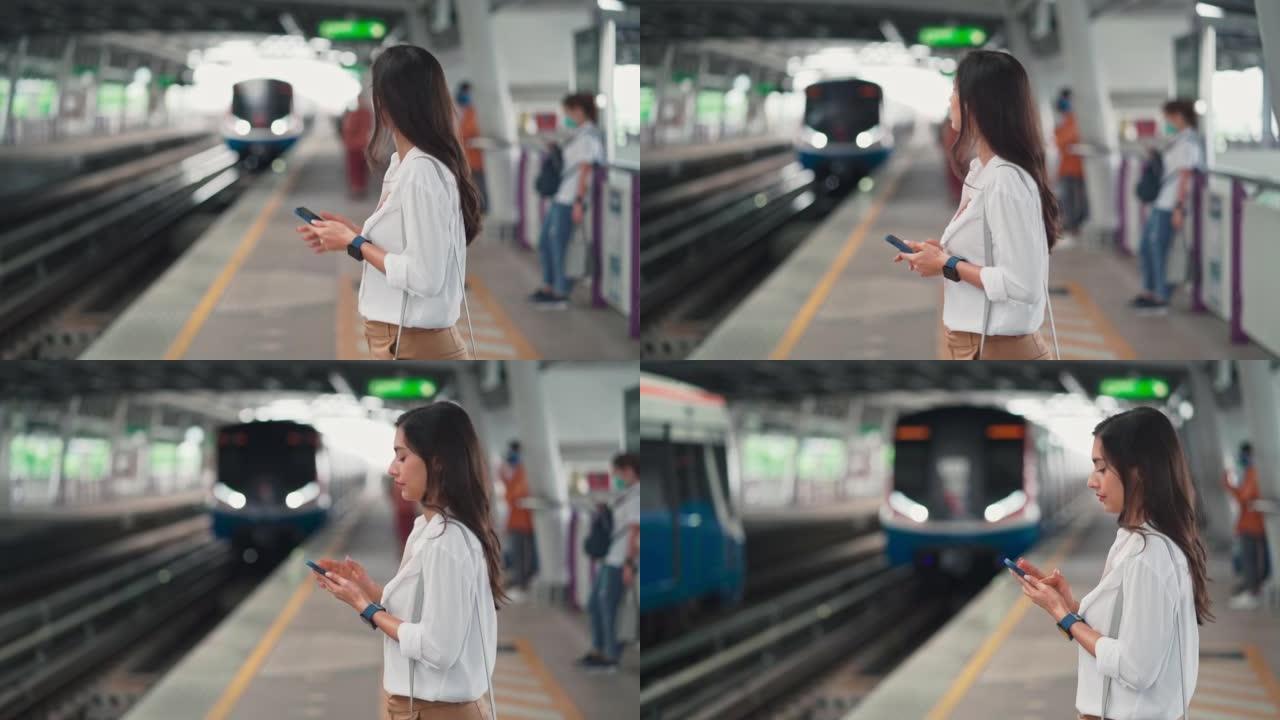 女人在地铁站等火车时使用电话