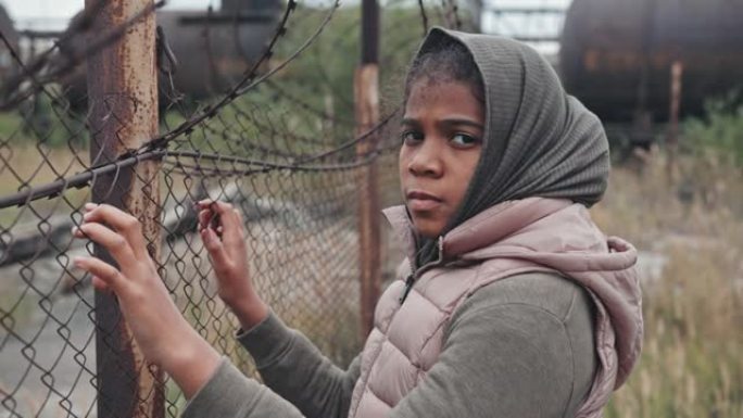 铁丝网围栏上的难民女孩肖像