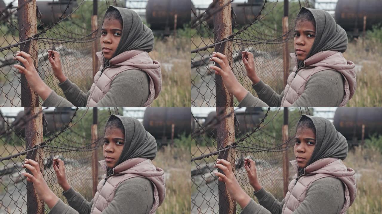 铁丝网围栏上的难民女孩肖像