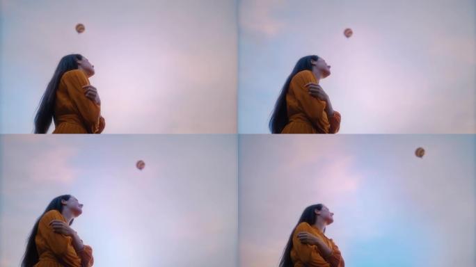 年轻女子在多云的天空抬头看着热气球