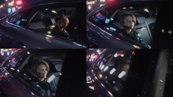 兴奋的小男孩坐在汽车后座上，晚上通勤回家。快乐而微笑的年轻孩子被带霓虹灯的城市街道上带回家。电影镜头