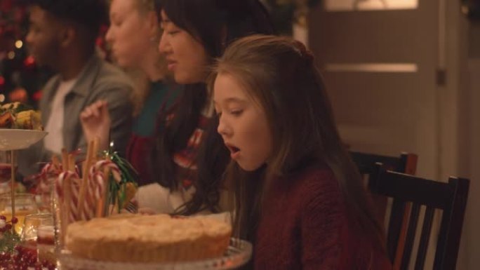 亚洲年轻女孩在家庭圣诞大餐中吃饭