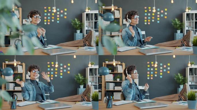 快乐的女孩办公室工作人员戴着耳机在办公室跳舞独自在房间里玩耍