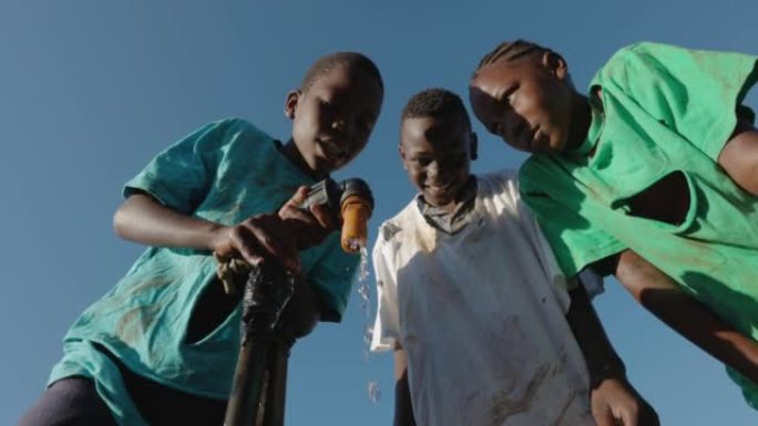 小黑人非洲儿童在公共水龙头等待水的特写。水危机。贫困。干旱。气候变化。全球变暖。不平等
