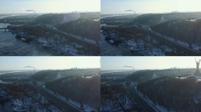 寒冷晴朗的冬日早晨冰冻第聂伯河的美丽空中风景和基辅日出下的祖国纪念碑。
