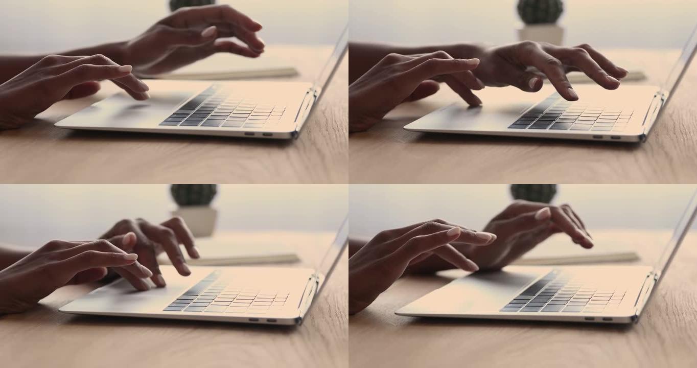 关闭年轻的混血女人在笔记本电脑键盘上打字。