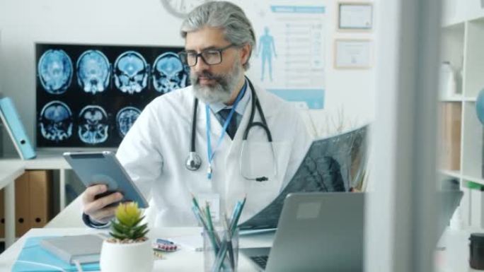 经验丰富的医生在医院学习MRI图像并使用计算机打字