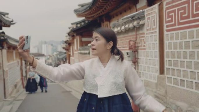 亚洲女性影响者正在韩国的一个旅游景点自拍。