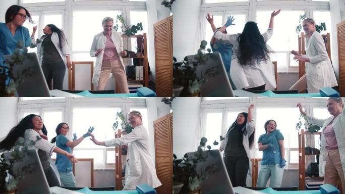 三个有趣的快乐的多民族女医生在工作实验室一起跳舞，庆祝战胜冠状病毒大流行。