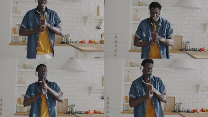 无忧无虑的非洲裔美国人在想象中的麦克风里跳舞和唱歌，在家里的厨房里玩得开心