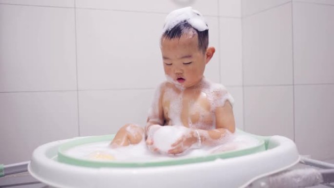 男婴在浴缸浴室洗澡和玩耍