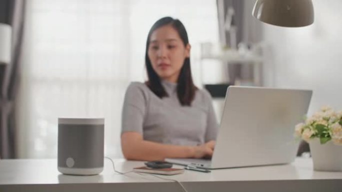 亚洲女性在家中使用智能扬声器