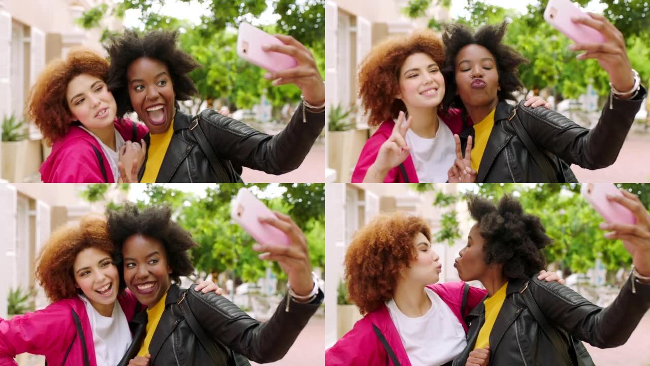 顽皮的女性朋友在城市公园外面用手机自拍。愚蠢的非洲女孩拉着脸在社交媒体上发帖。年轻女性一起微笑和大笑