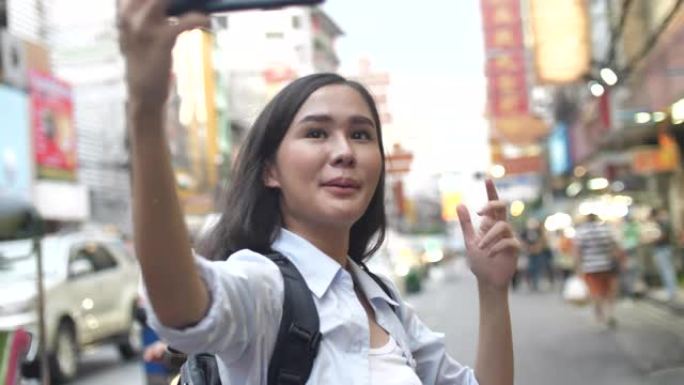 一名女性游客在旅游博客上发帖，在行走过程中使用智能手机摄像头