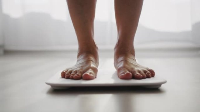 健康量表上测量体重的高级女性