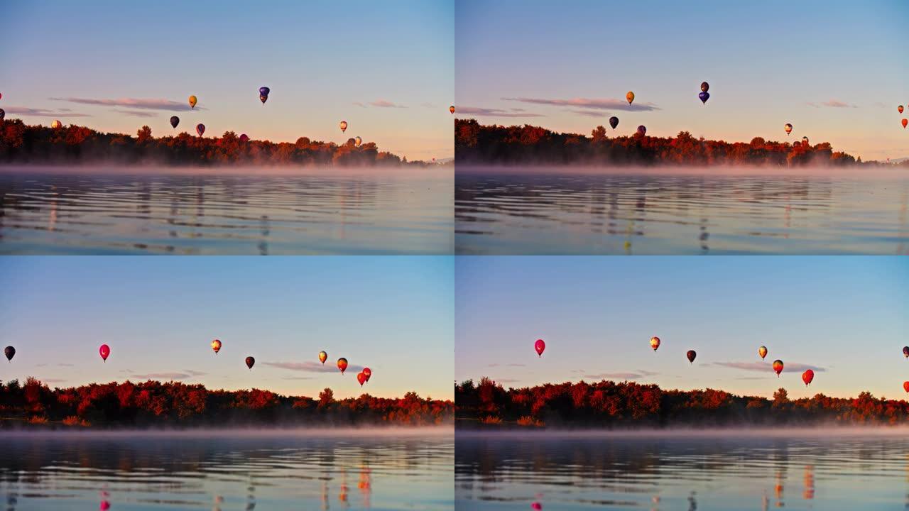日出时，热气球漂浮在宁静的雾湖上
