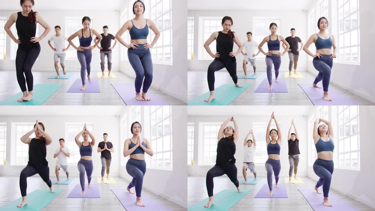 年轻的亚洲运动型有魅力的人与教练一起练习瑜伽课。亚洲妇女团体在健身工作室锻炼健康的生活方式。