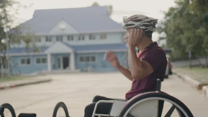 亚洲男子适应性运动员训练后坐在轮椅上。