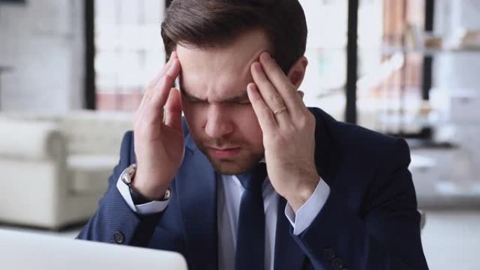 紧张疲惫的年轻公司员工患有头痛。