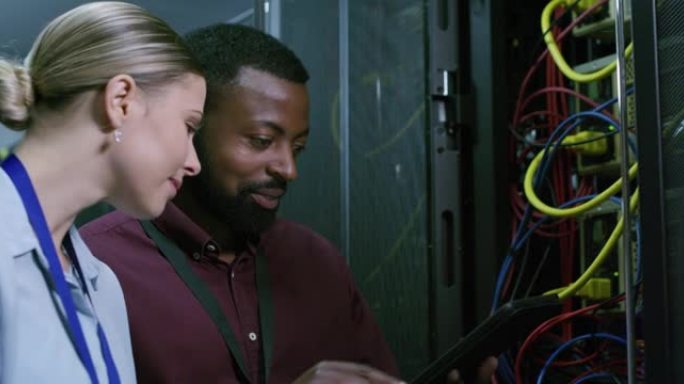 在服务器机房工作时使用数字平板电脑的年轻男女的4k视频片段