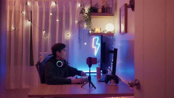 拥有手臂残疾拖缆的职业玩家在他的电脑上玩游戏。