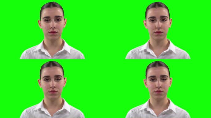 女人在绿色背景前看着相机表情严肃的视频。绿屏，4k视频。