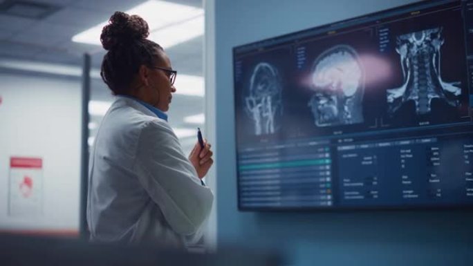 医学科学医院:自信的黑人女性神经学家，神经学家，神经外科医生，用MRI扫描看电视屏幕，思考病人的治疗