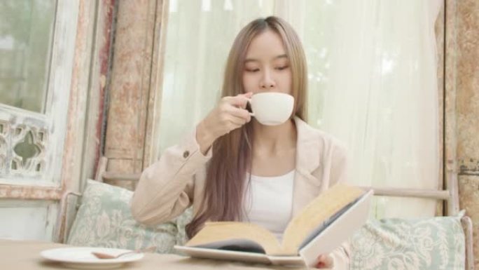 放松美丽的亚洲女人在舒适的客厅里放松时看书。