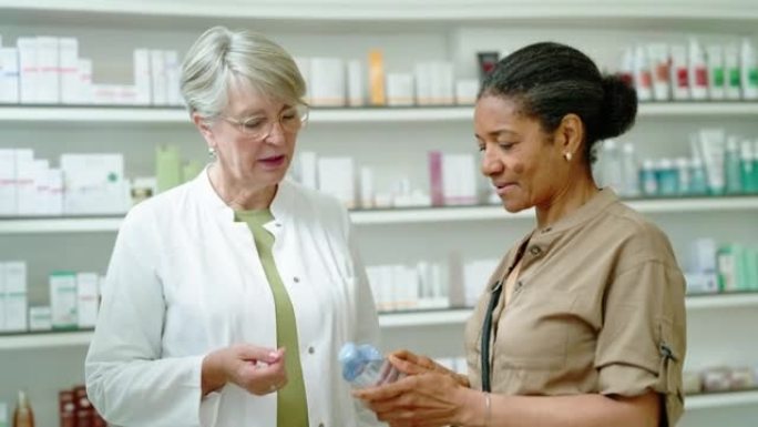 成熟的女化学家帮助顾客在药房购买产品