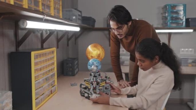 老师帮助女孩使用机器人太阳能系统模型