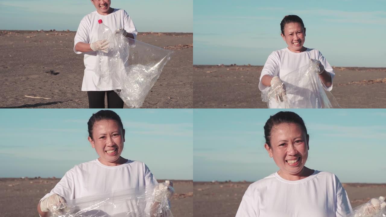 微笑的女人用塑料清洁海滩