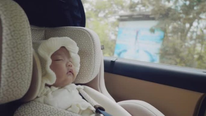 公路旅行时坐在汽车座椅上的小婴儿。