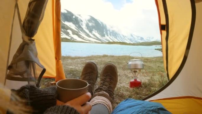 4k视频片段，一个无法识别的女人独自坐在帐篷里，在挪威喝杯咖啡