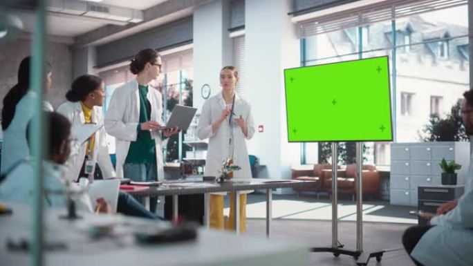 兴奋的年轻女性专家做了一个演讲，使用绿屏监视器，并在实验室与她的同事交谈。工程师团队开会，在使用技术