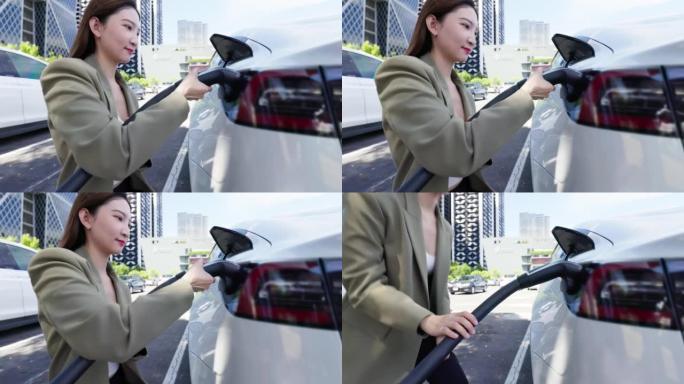 asian woman charging electric car