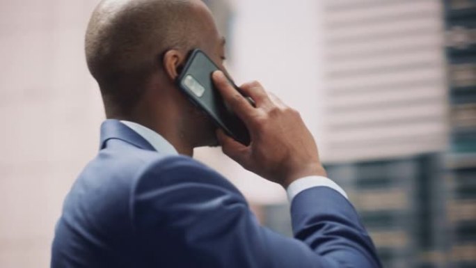 360度街拍: 自信的黑人商人在城市智能手机上聊天的肖像。成功的非洲裔美国企业家使用手机打电话。跟踪