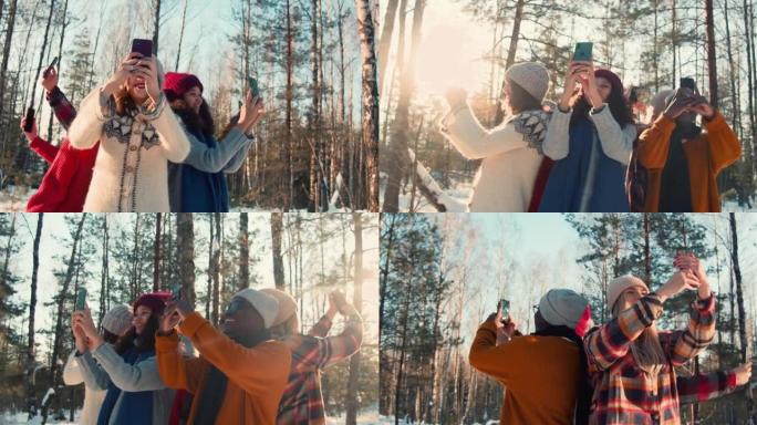 相机在快乐的多民族朋友周围移动，每个人都在阳光明媚的冬季森林慢动作中拍摄个人自拍照。