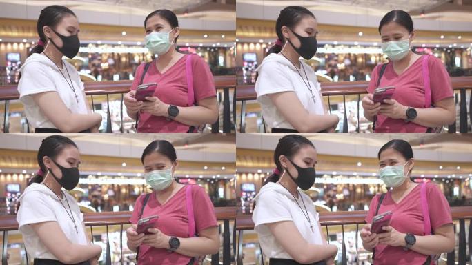 带防护口罩的母女策划在商场购物