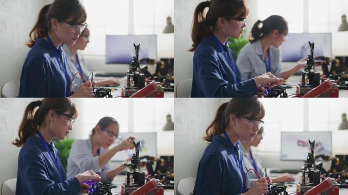 工程师在控制室测试机器人手。女性在做她的机器人项目，她测试传感器信号。技术与创新理念