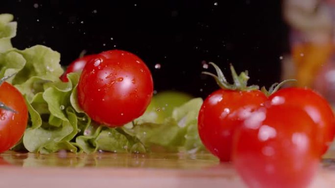 宏观: 洗过的樱桃番茄在切菜板上滚动时，水溅起。
