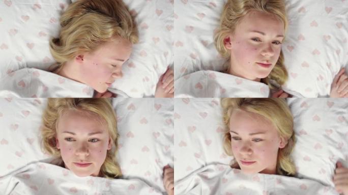 4k视频片段，一名年轻女子在床上醒来并感到不高兴