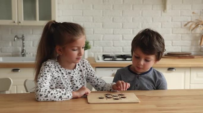 快乐的小孩兄弟姐妹玩木板游戏。