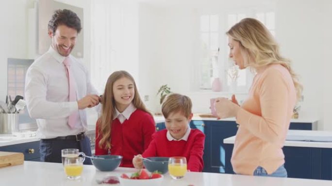 父母帮助穿着校服的孩子在厨房柜台吃早餐时做好准备
