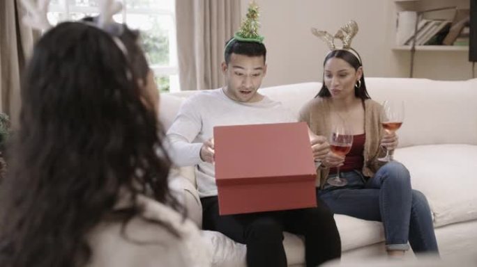 一群朋友在家里休息室打开礼物圣诞礼物的4k视频片段