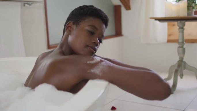 非裔美国迷人女性在浴室泡沫浴缸中放松的简介