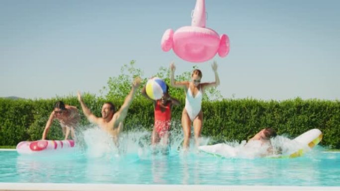 穿着泳衣的年轻多民族朋友的慢动作在阳光明媚的日子里，在游泳池里享受着他们的暑假，那里有五颜六色的充气